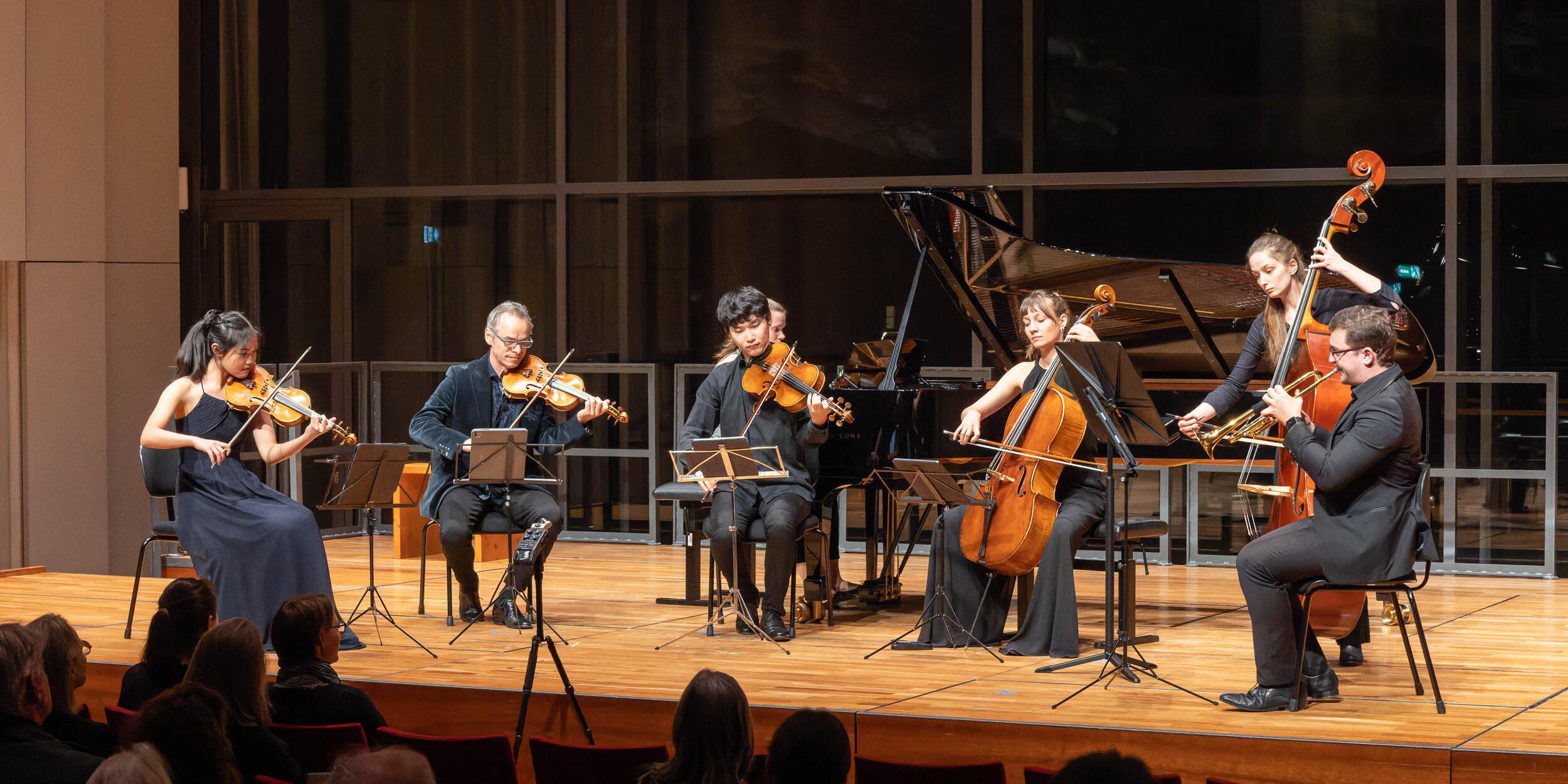 Musiker*innen auf einer Bühne, Streichquartett, Piano, Klarinette und Kontrabass | © Christian Schneider