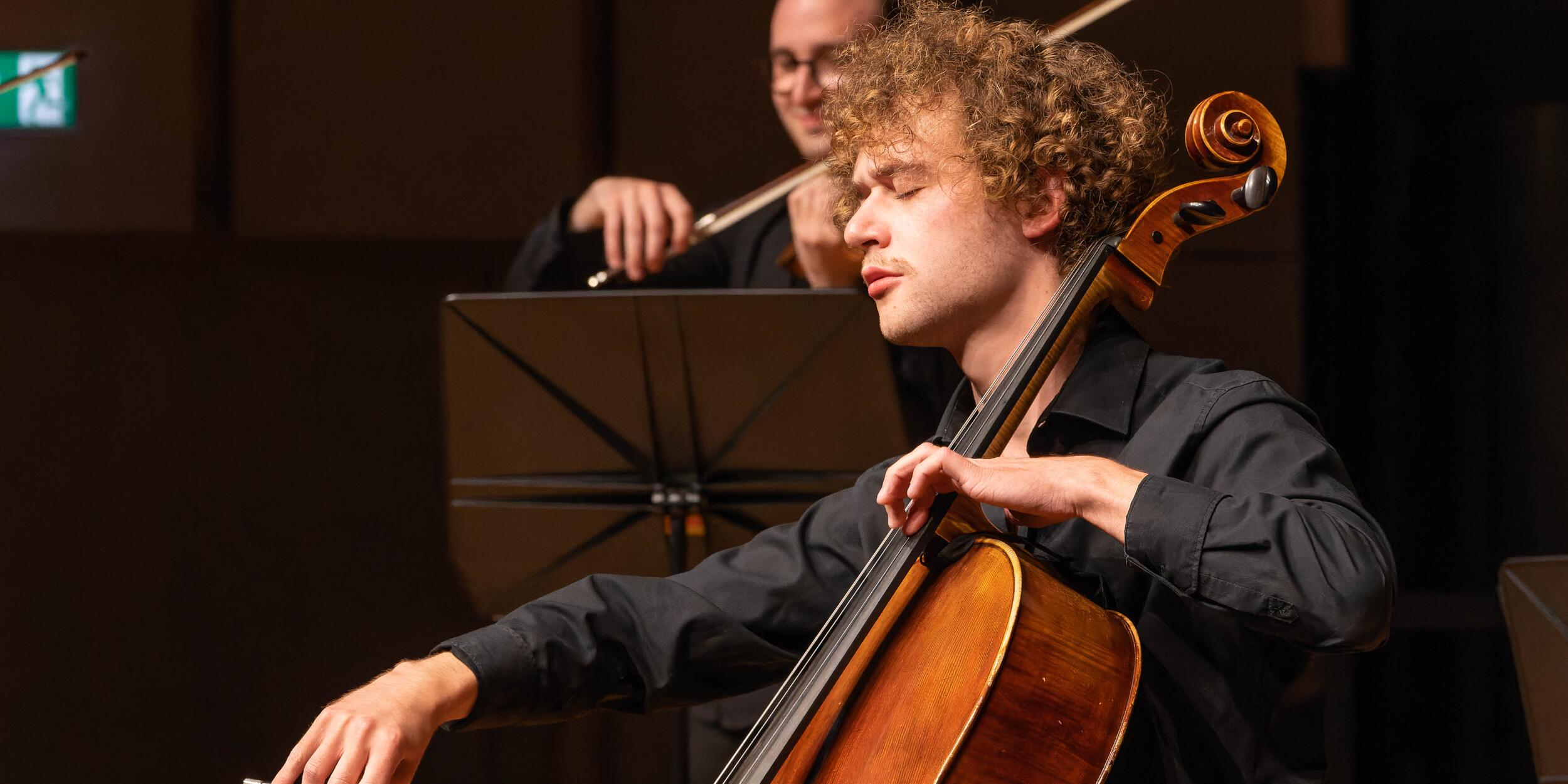 Cellist mit Locken auf Bühne | © Christian Schneider