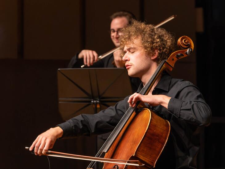 Cellist mit Locken auf Bühne | © Christian Schneider