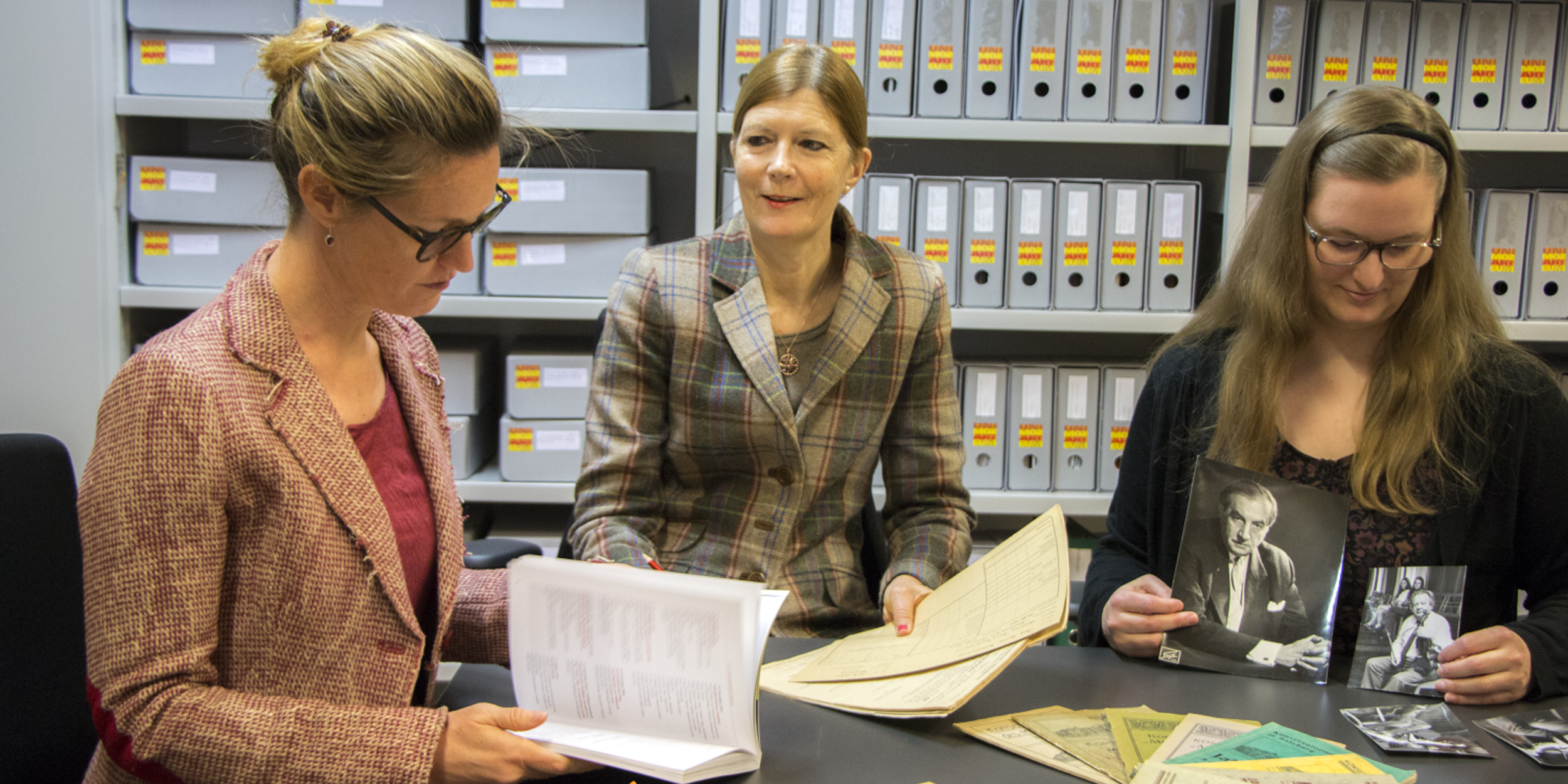 Team des Kunst-Archiv-Raum an einem Tisch mit alten Fotografien und Dokumenten | © Universität Mozarteum