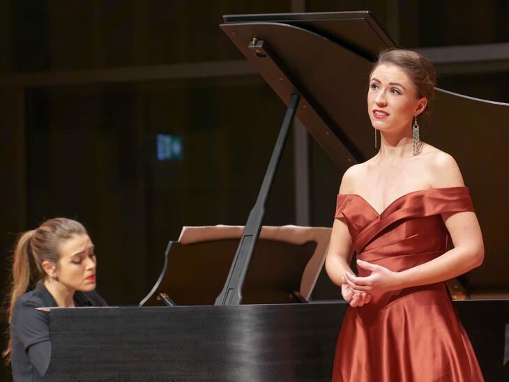 Veronika Loy in okerfarbenenm Kleid auf der Bühne des Solitär | © Christian Schneider