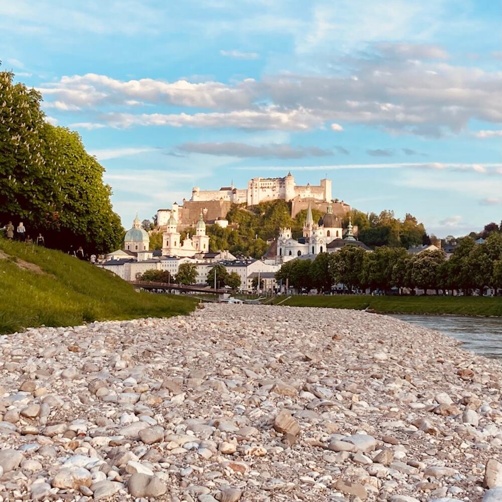 Salzburger Festung in früher Abendstimmung, im Vordergrund Sandbank der Salzach